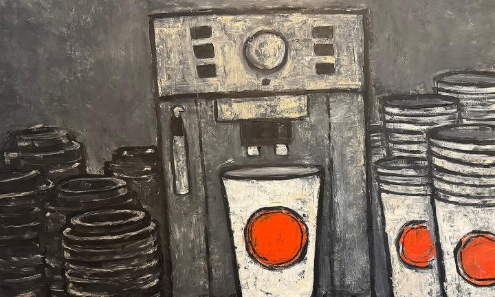 a coffee maker with white paper cup emblazoned with a bright orange dot