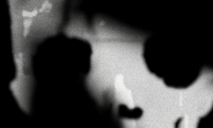 Grainy image of figures as seen through a digital skull.