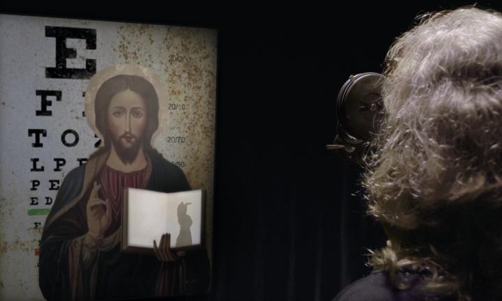 figure with optometry glasses looking at eye chart and Jesus making a shadow puppet bunny 