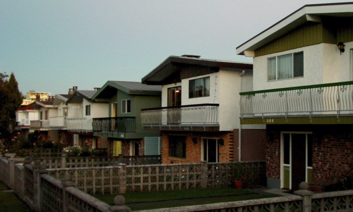 photo of connected backyards with stone fences and houses with large balconies