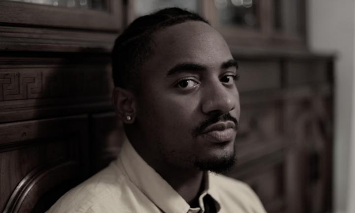 man seated in front of china cabinet David Gaines Midwest Video Poetry Fest still