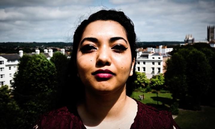 poet Neelam Saredia-Brayley against backdrop of white buildings