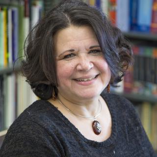 headshot of author with books in background