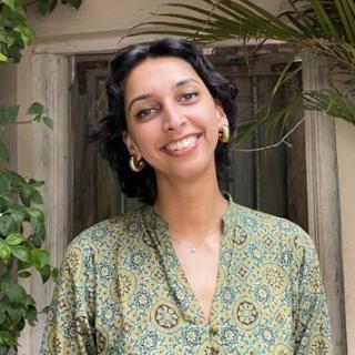 Smiling dark-haired woman in front of door 
