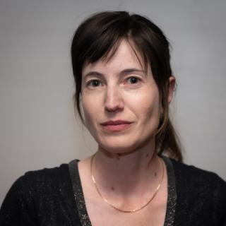 Renee Lepreau, woman with dark brown hair in a dark shirt and gold necklace