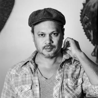 poet Nicholas Gulig in a cap and plaid shirt